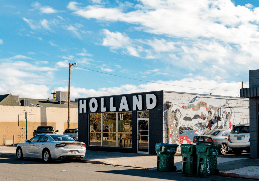 The exterior of a black building, The Holland Project a venue space for art and live music.